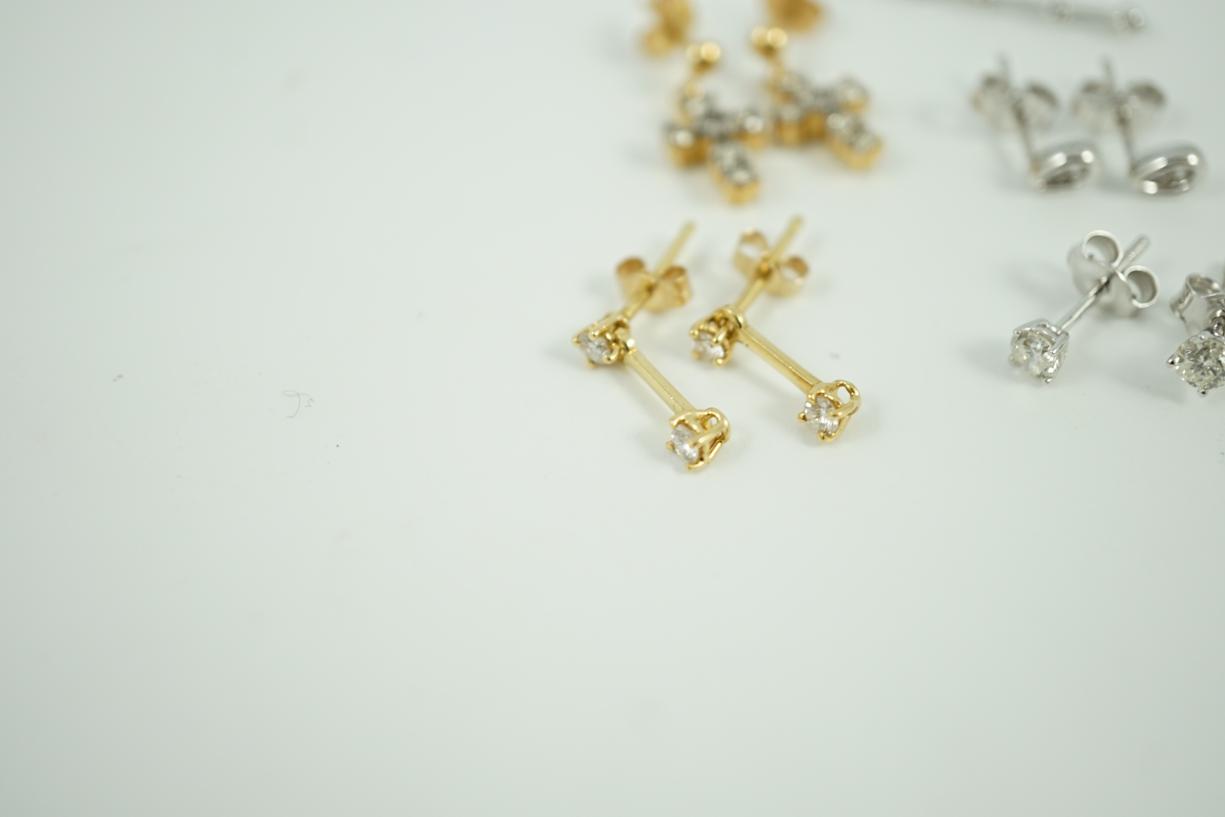 Three pairs of 18ct white gold and diamond set ear rings, including solitaire ear studs and two other pairs of 18ct gold and diamond set ear studs including cross, largest 24mm, gross weight 6.4 grams.